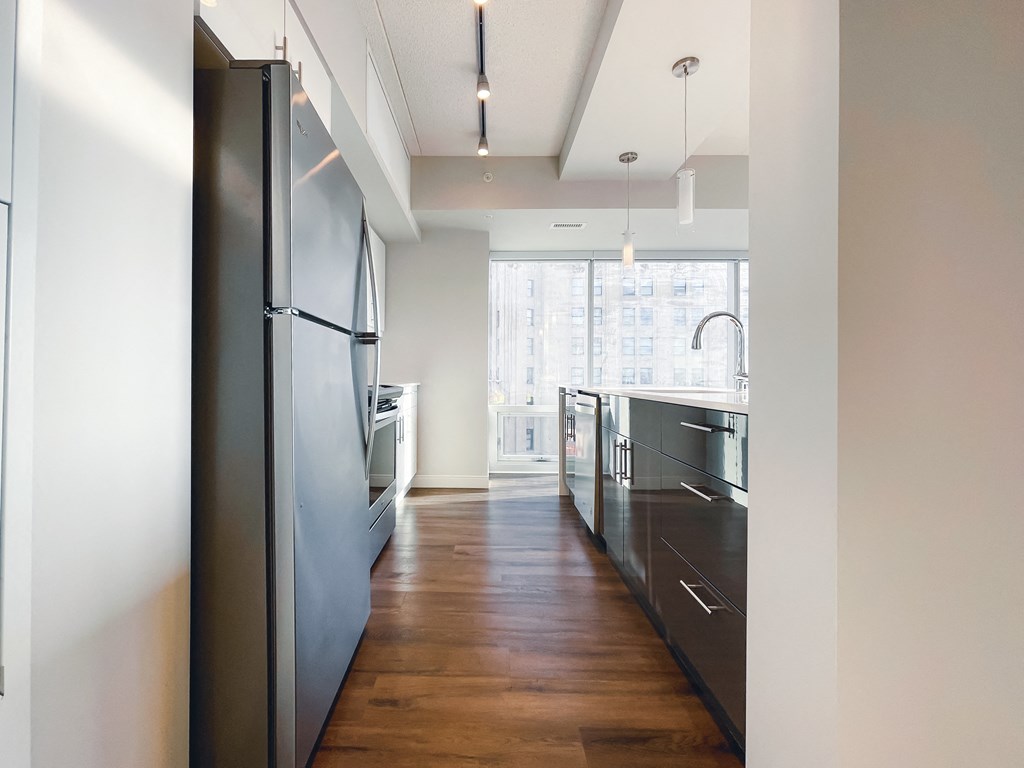 a kitchen with black cabinets and stainless steel appliances and a window