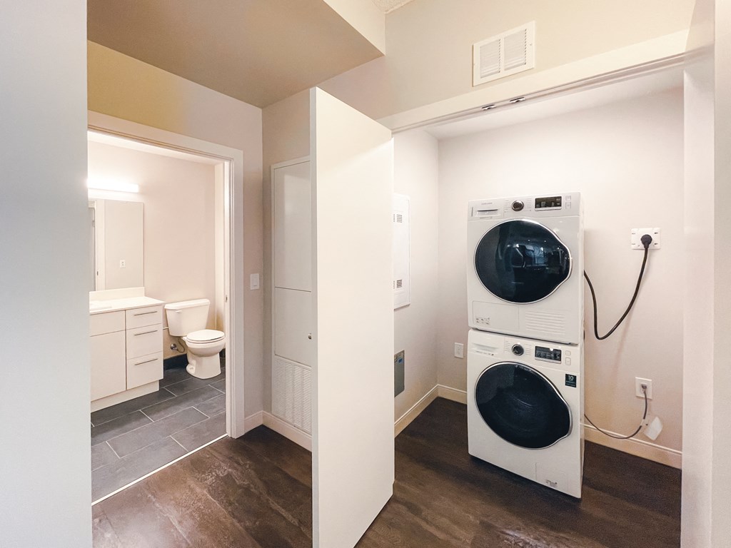 a washer and dryer in a room with a toilet and a bathroom
