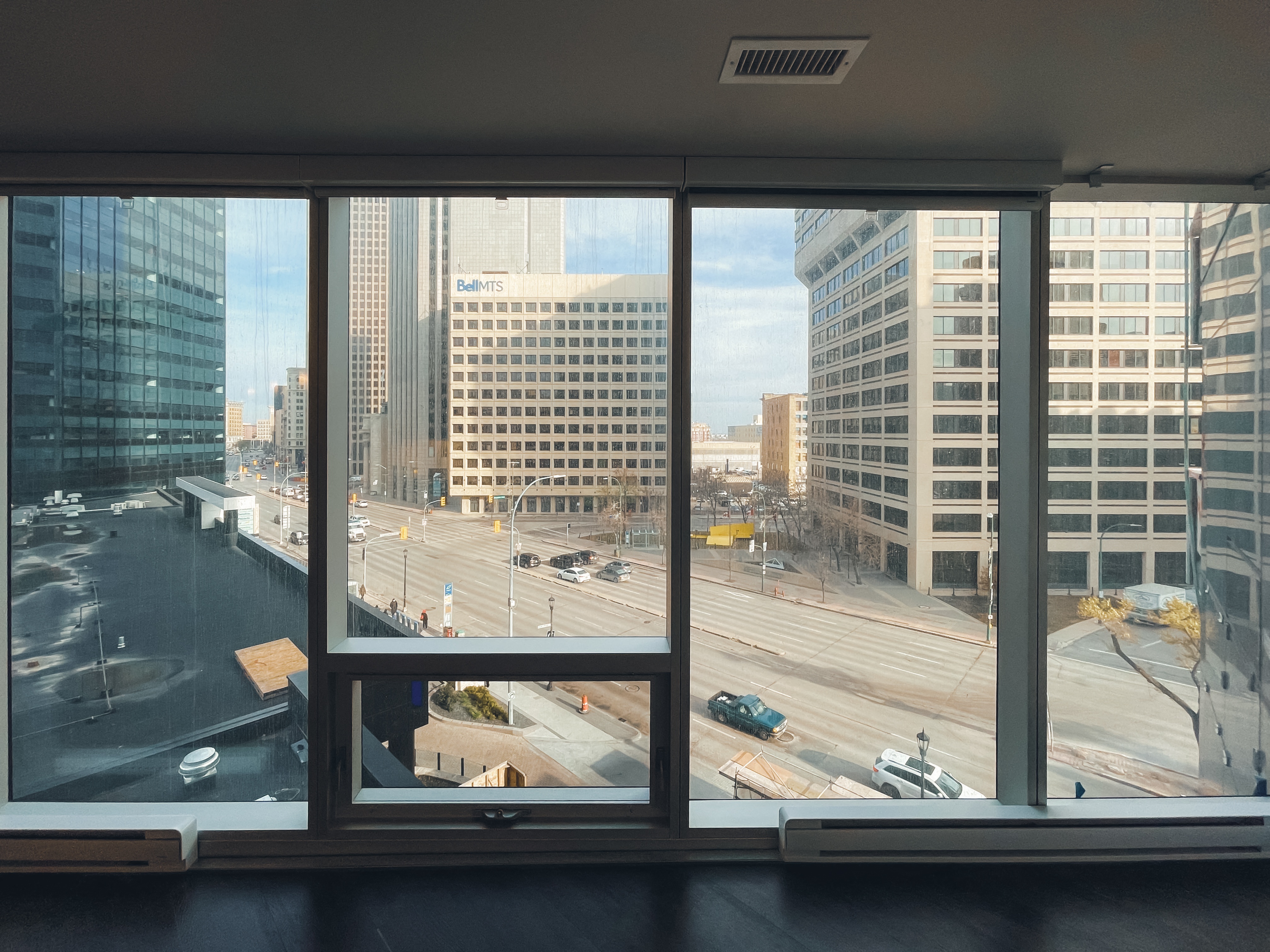a view of the city from a window in a high rise building