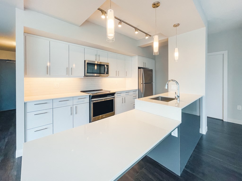 a kitchen with white counter tops and white cabinets