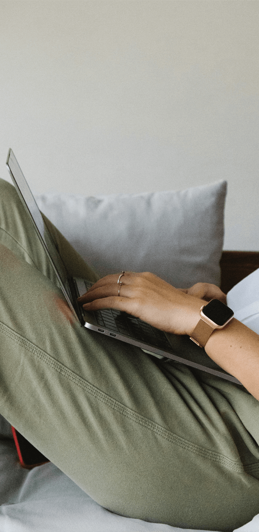 a person laying on a bed with a laptop