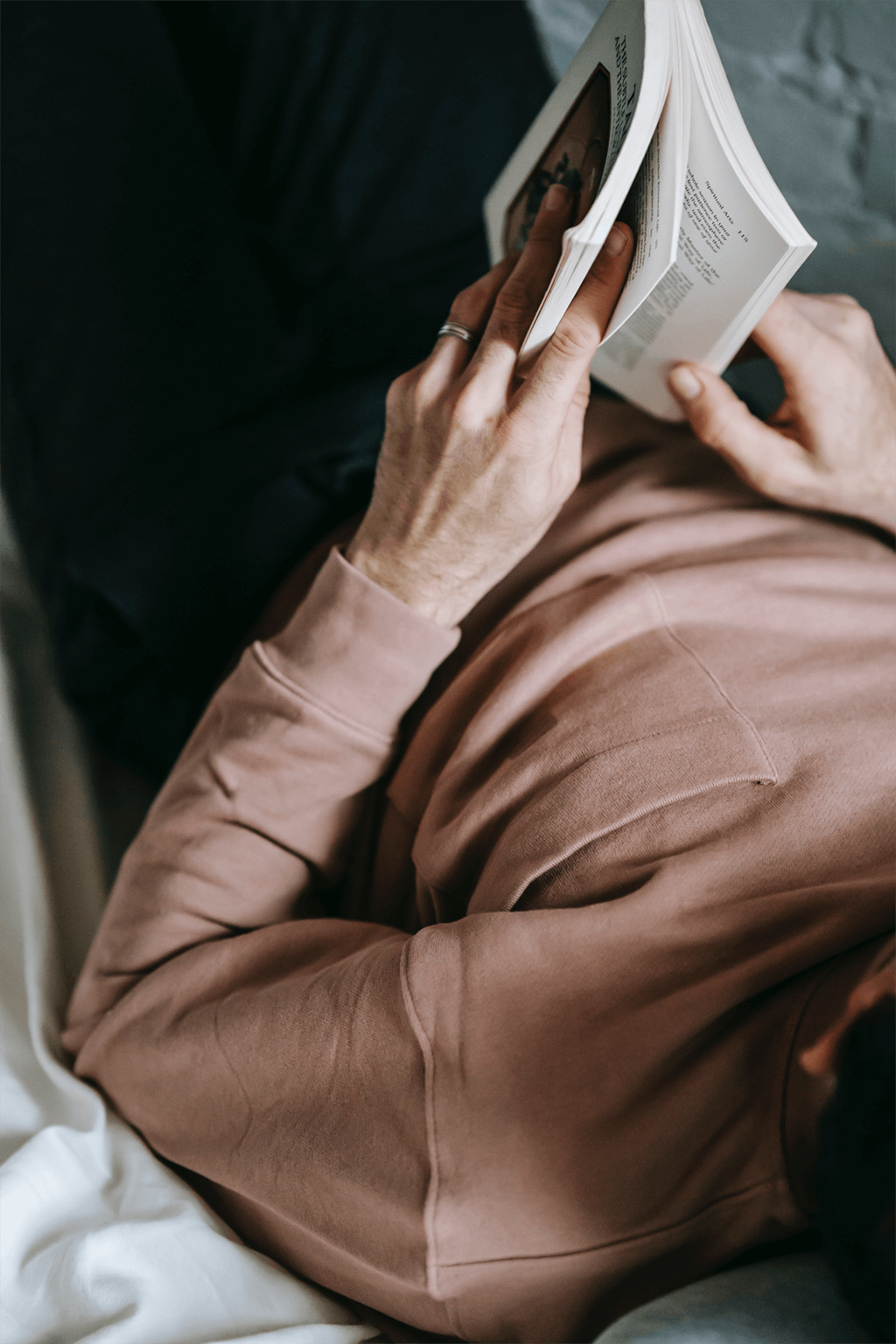 a man reading a book on a couch