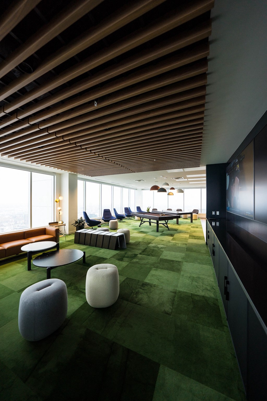 a lounge area with tables and chairs and a large window