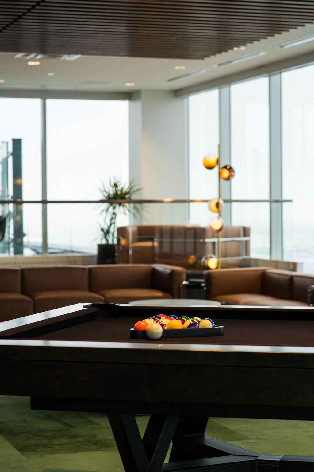a pool table in a living room with large windows