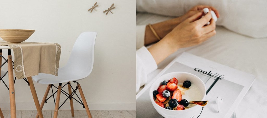 a woman sitting at a table with a bowl of fruit and a book