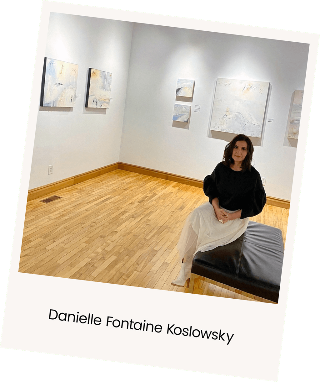 a woman sitting on a couch in a room with paintings on the wall