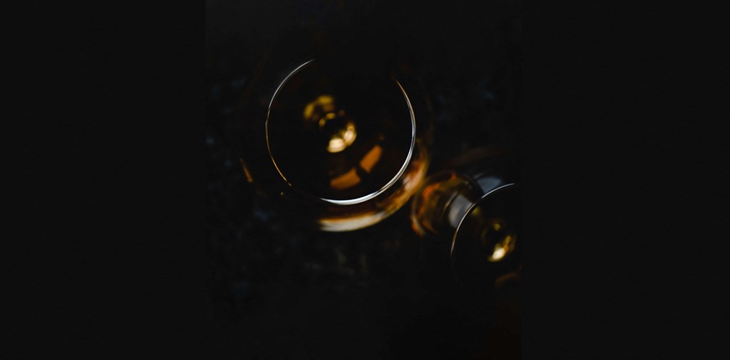 a glass of wine on a table in the dark