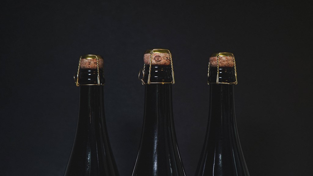 three bottles of wine in a black background