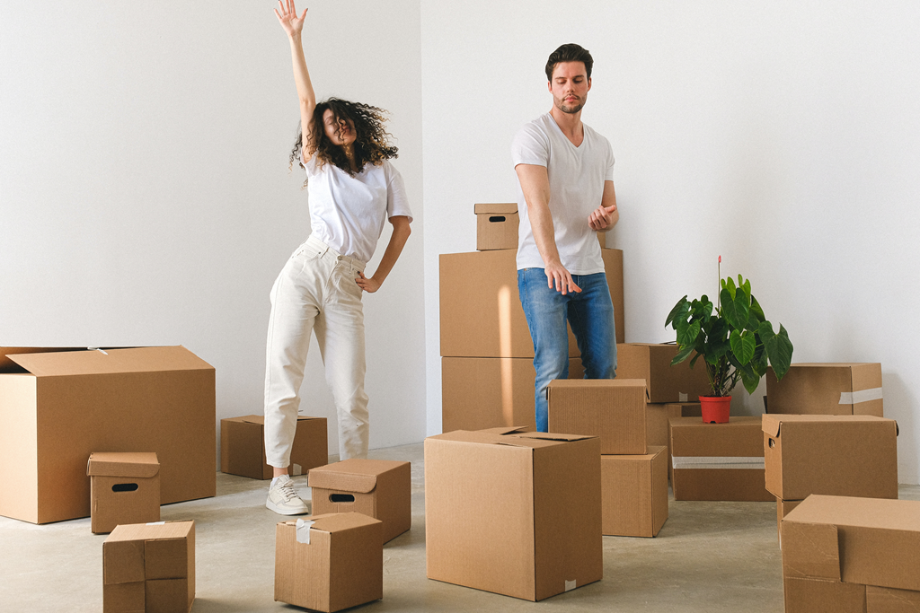 two people standing in a room full of cardboard boxes
