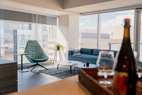 a living room with a couch and a table and a bottle of wine
