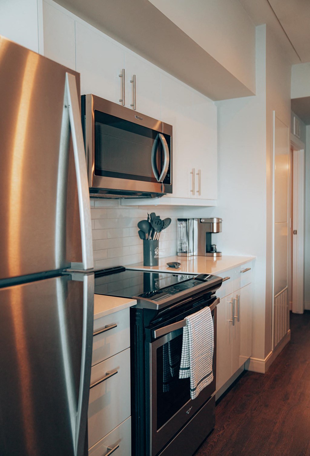 a kitchen with white cabinets and stainless steel appliances