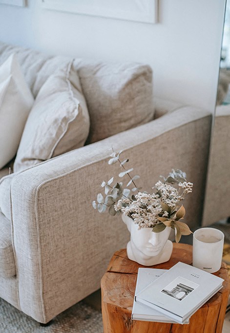 a living room with a couch and a vase with flowers on a table
