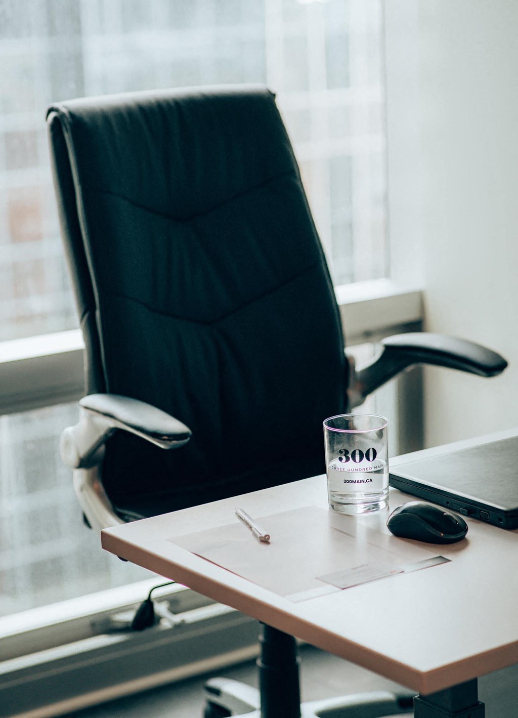 a glass of water on a desk next to a laptop