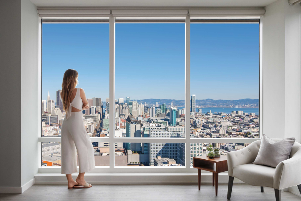 a woman looking out of a window at a city skyline