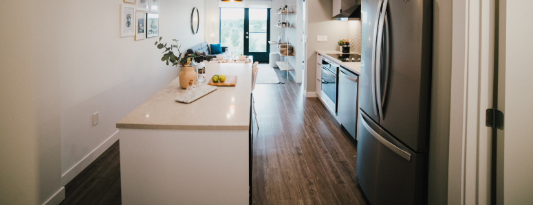 a view of a kitchen with white cabinets and stainless steel appliances