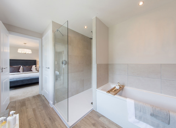 a bathroom with a shower and a tub and a bed