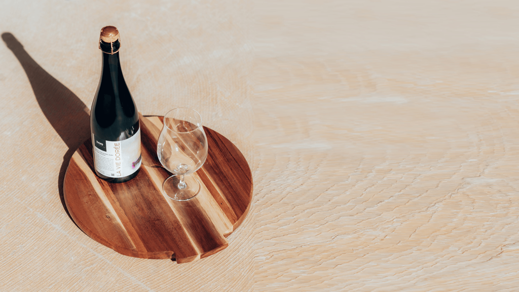 a bottle of wine and two glasses on a wooden tray