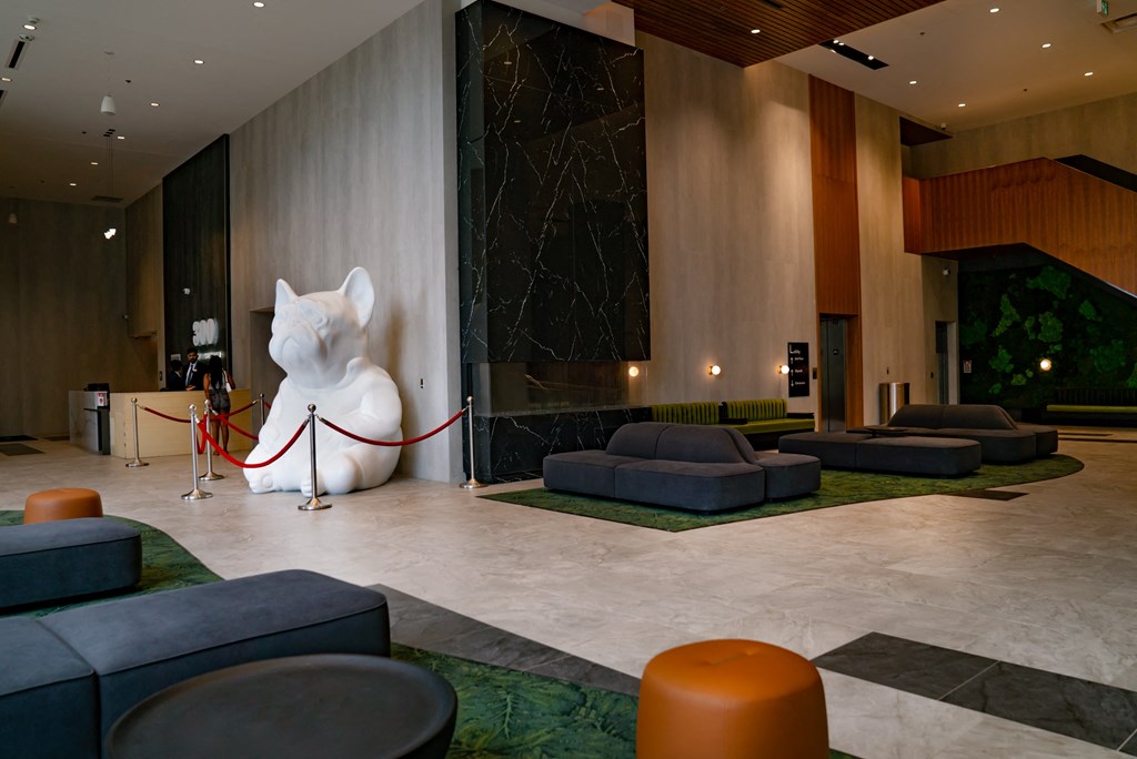 a large white cat statue sits in the middle of the lobby of a hotel