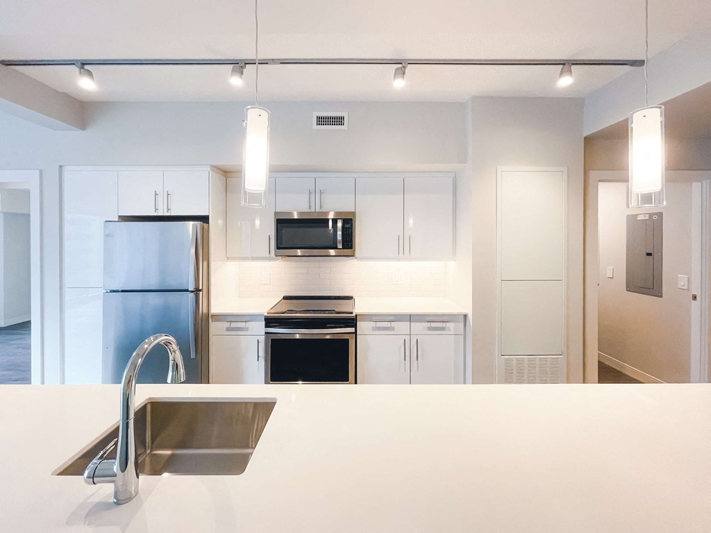 a kitchen with white cabinets and stainless steel appliances