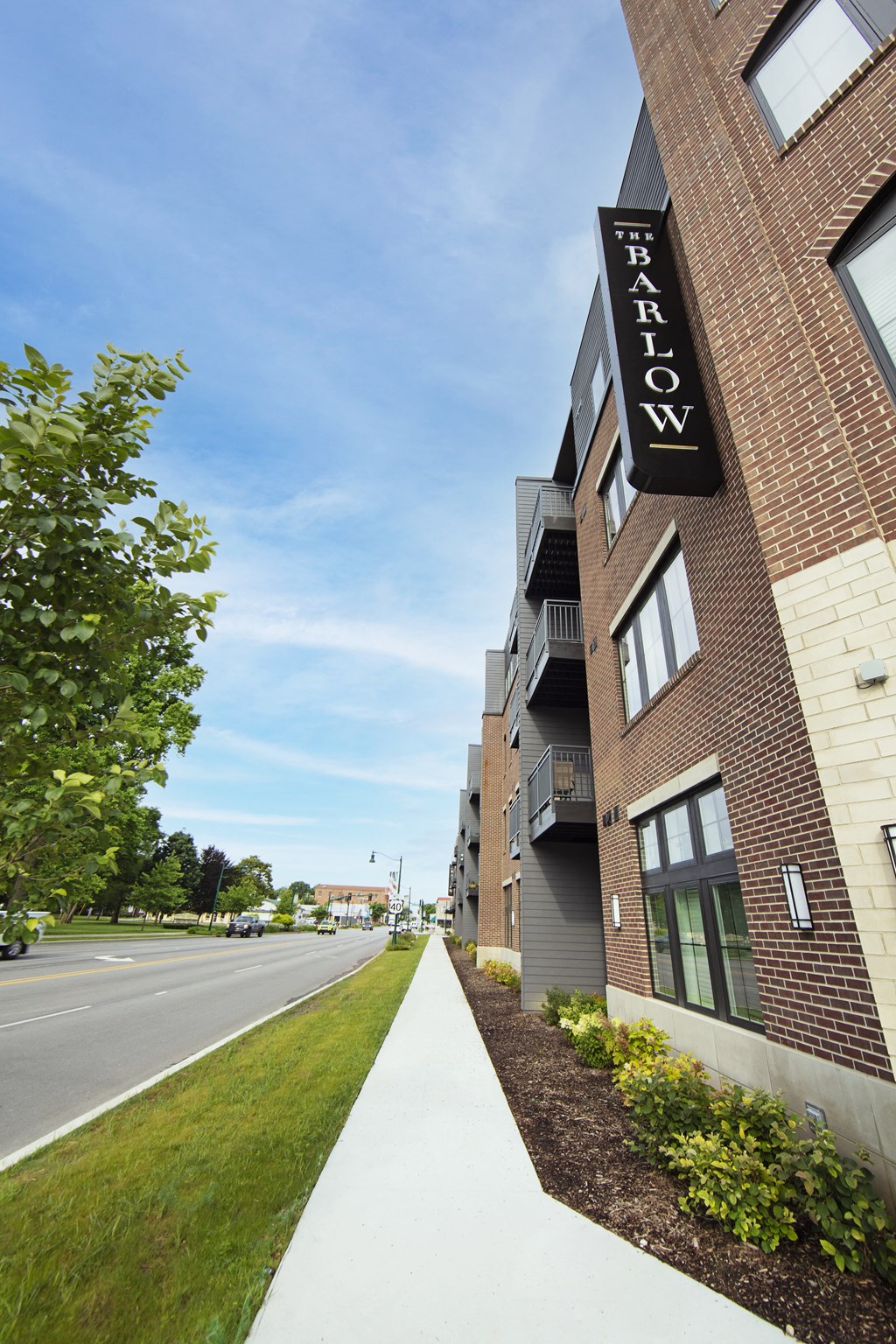 an apartment building with a sign on the side of the street