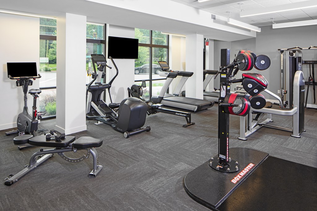 a gym with cardio machines and other exercise equipment in a building