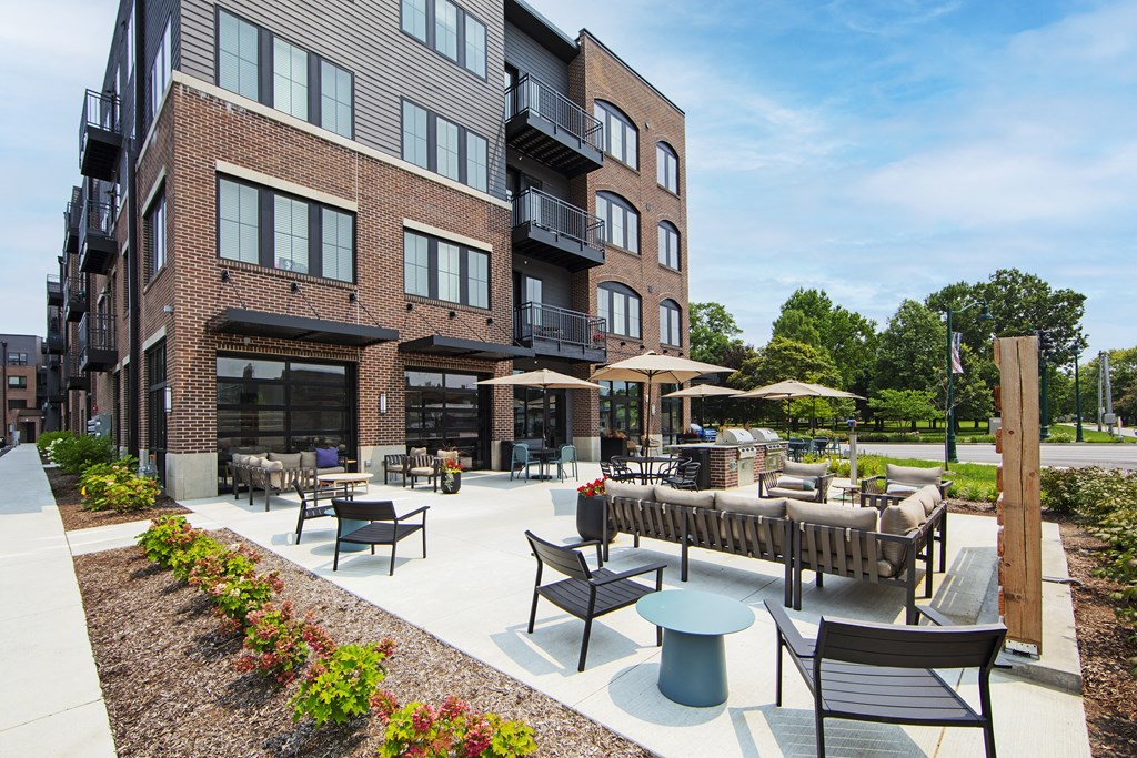 a patio with tables and chairs outside of a building