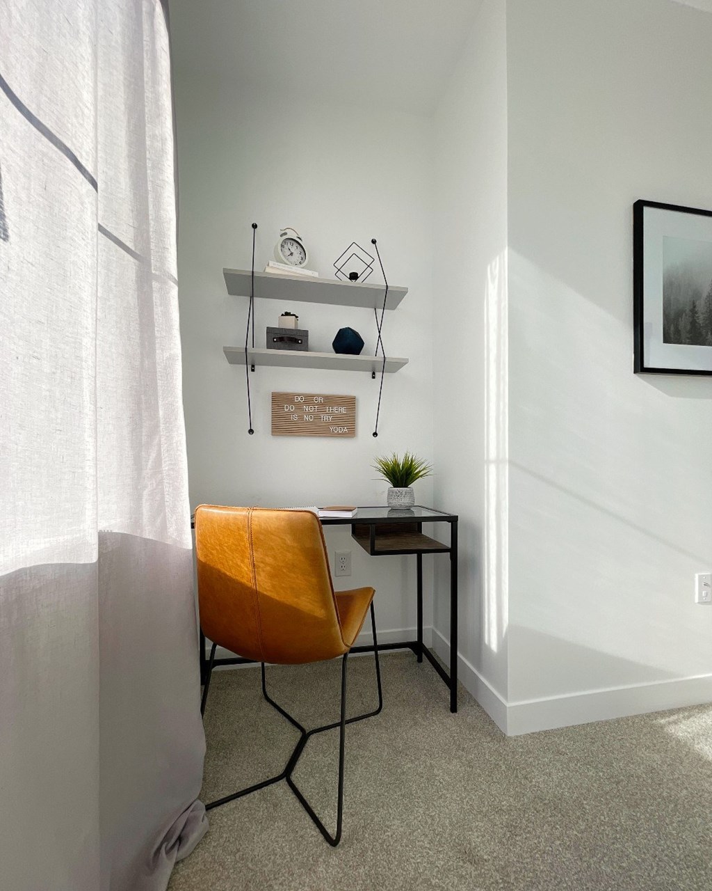 A chair sits in front of a desk with a plant on it.
