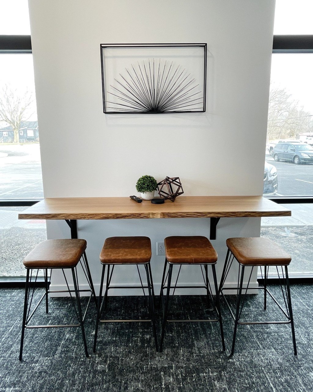 A table with three stools and a plant on it.