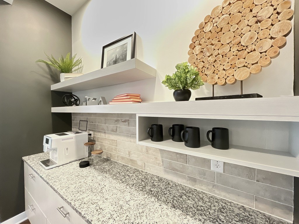 A kitchen counter with a toaster, a plant, and a picture frame on the shelf.