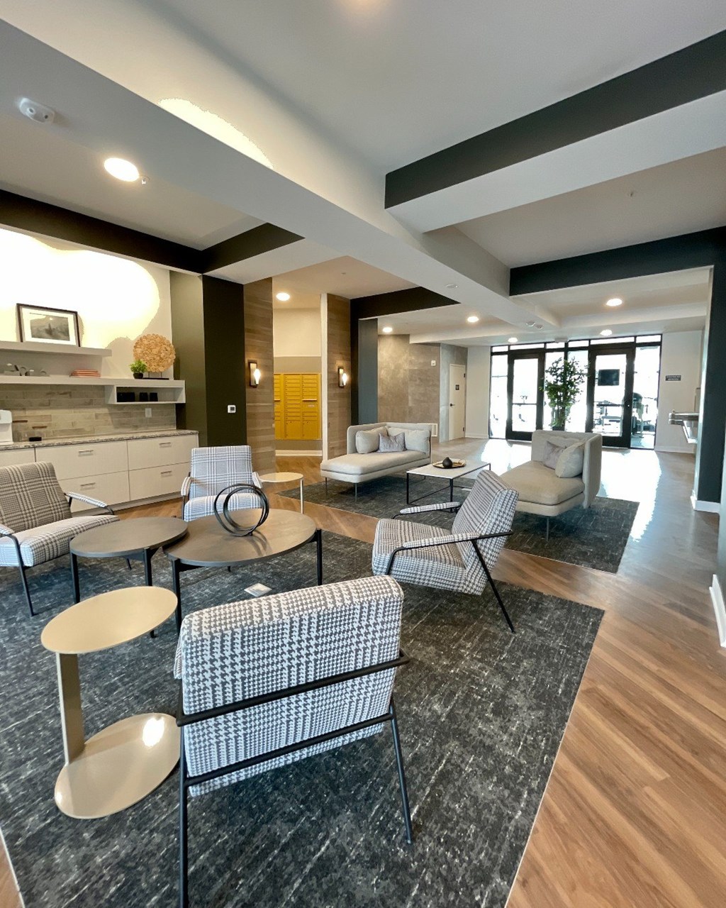 A modern living room with a grey sofa and a black and white checkered chair.