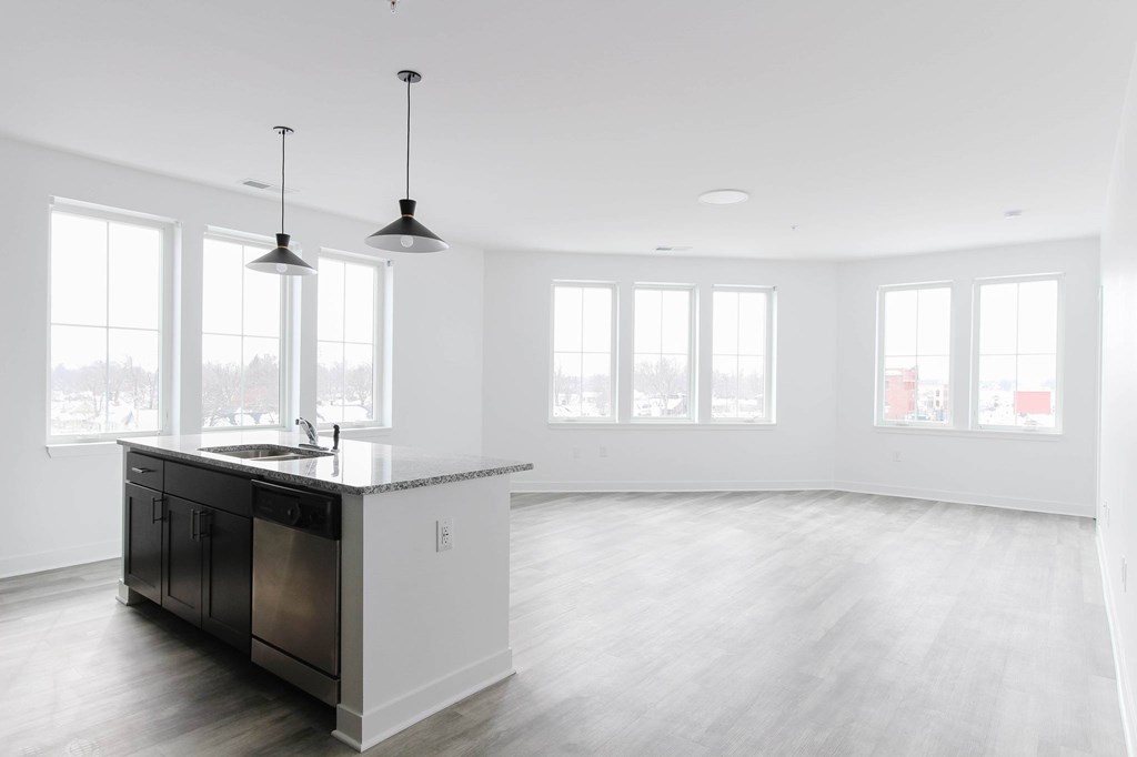 A kitchen with a sink, cabinets, and a window.