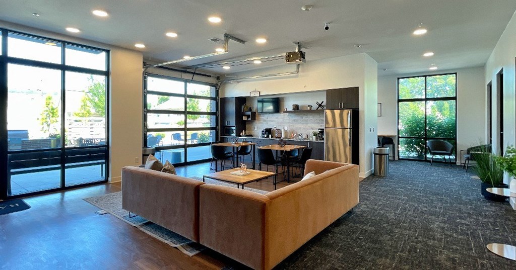 A modern open plan living and dining area with a kitchen in the background.