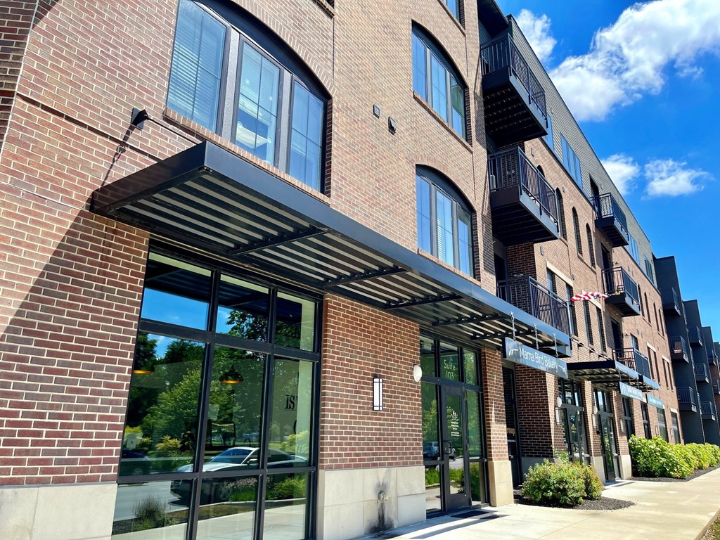 A modern brick building with a balcony on the second floor.