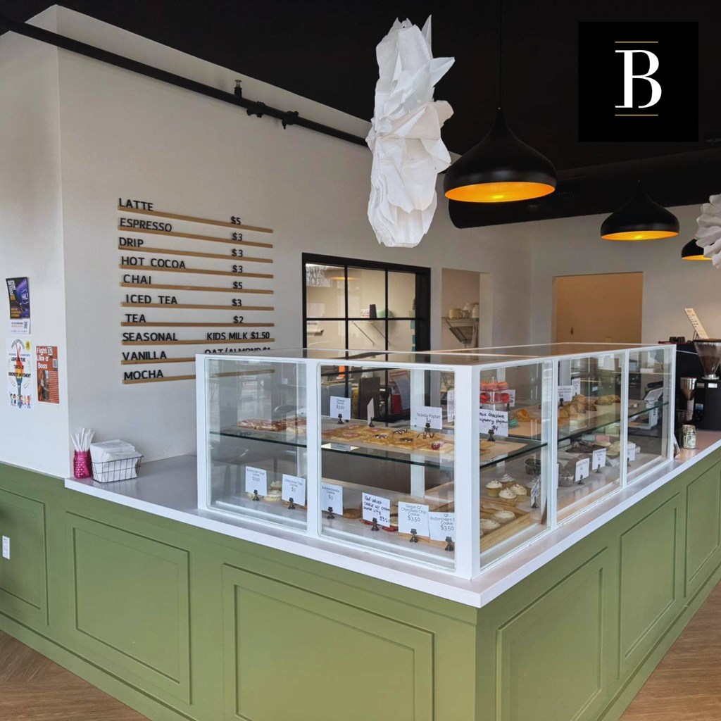 A coffee shop with a menu board showing prices for various drinks.