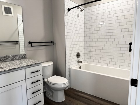 A white bathroom with a toilet, sink, and bathtub.