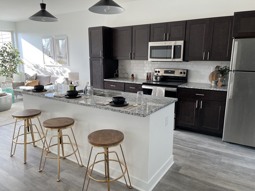 a kitchen with a large island with three stools
