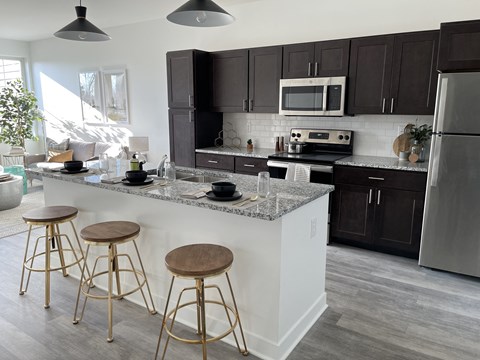 a kitchen with a large island with three stools