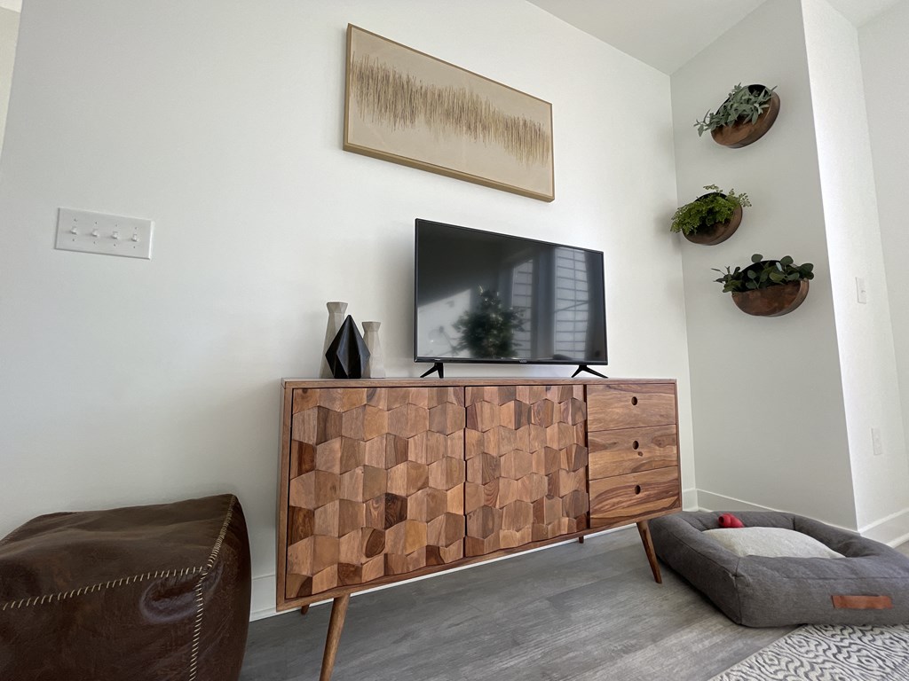 a living room with a television and a wooden entertainment center