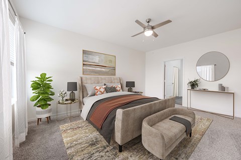 A bedroom with a large bed and a ceiling fan.