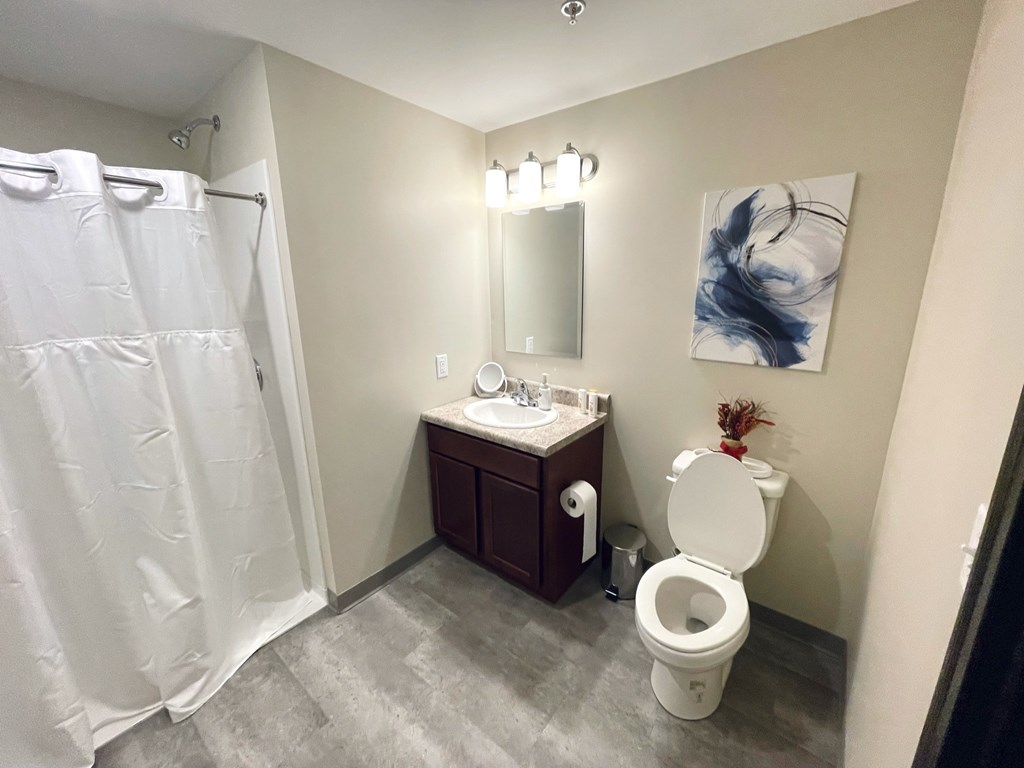 A bathroom with a toilet, sink, and shower.