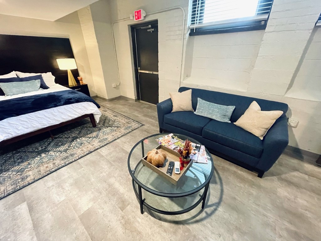 A room with a bed, a couch, and a coffee table.