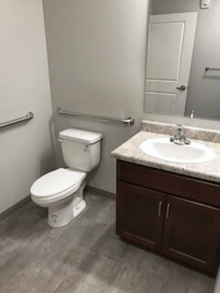 A white toilet sits next to a sink in a bathroom.