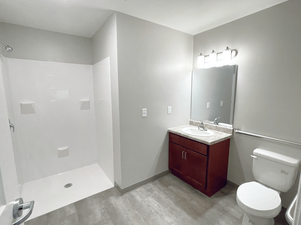 A bathroom with a toilet, sink, and shower.