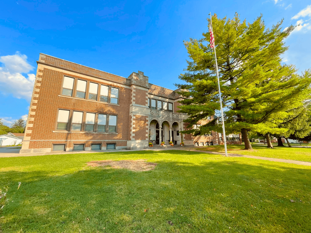 A building with a flag on a pole in front of it.