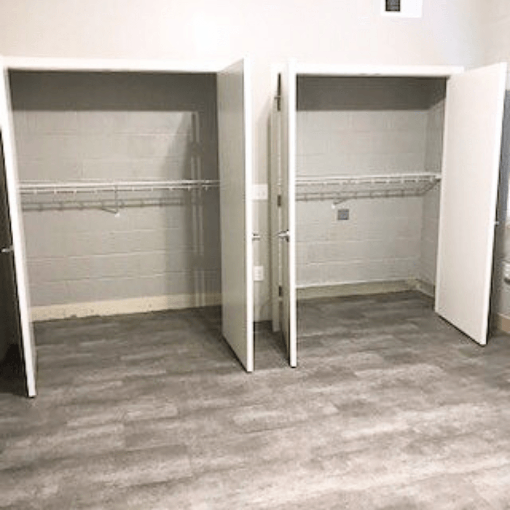 Two white closet doors open to reveal shelves.