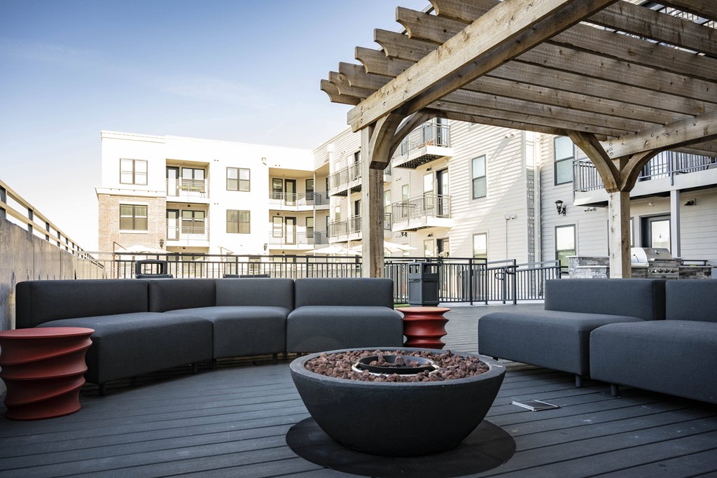 a patio with couches and a fire pit on a