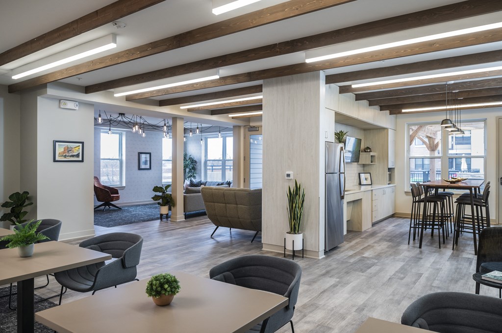 a living room with tables and chairs and a kitchen