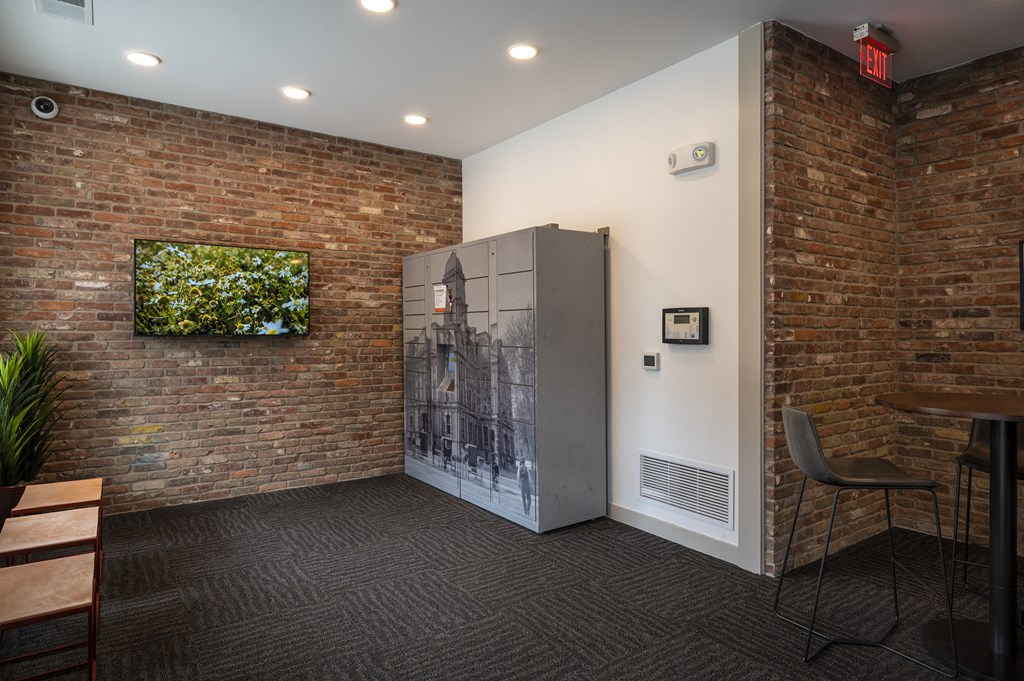 a room with a refrigerator and a brick wall