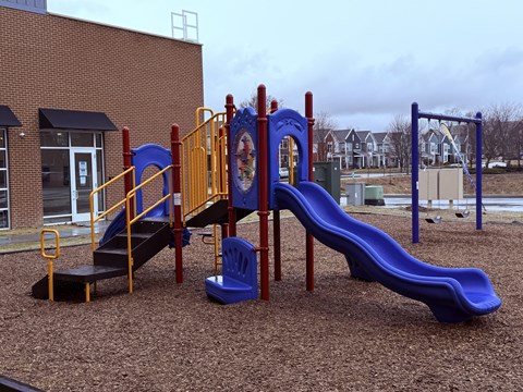 A playground with a blue slide and a yellow and blue play structure.