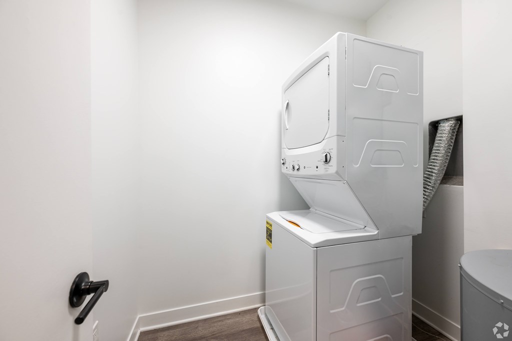 A white filing cabinet with a black handle is in a room with white walls.